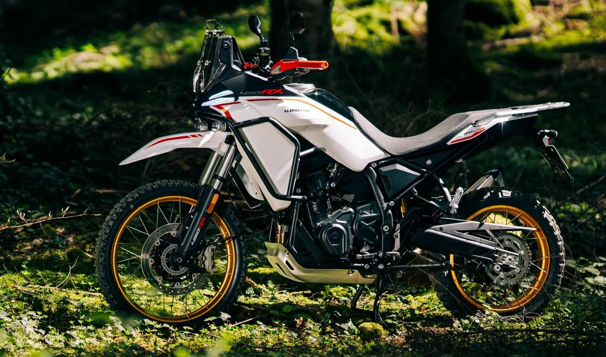 Une moto QJ Motor SRT 450 RX blanche dans une forêt