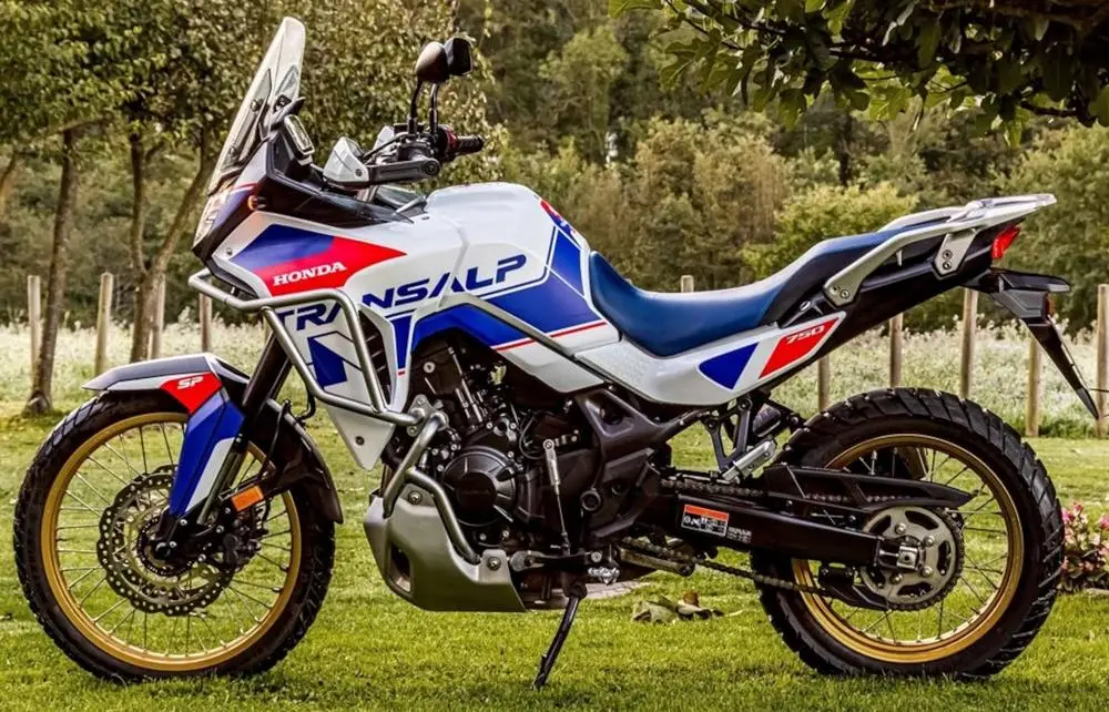 Une Honda 750 Transalp SP sur de l'herbe et des arbres derrière