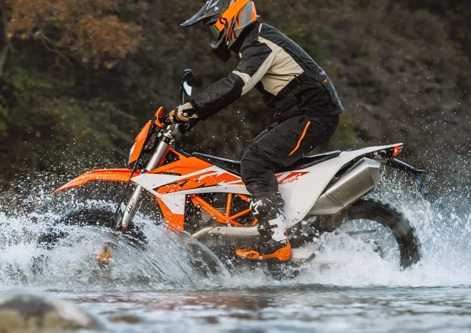 Une moto KTM 690 Enduro R de 2026 traversant une rivière