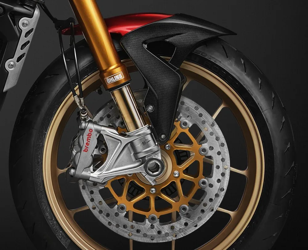 La fourche Öhlins, le garde-boue avant en carbone, un disque de frein, une roue dorée, un pneu et des etriers de frein Brembo Hypure de la moto MV-Agusta 950 Brutale série oro