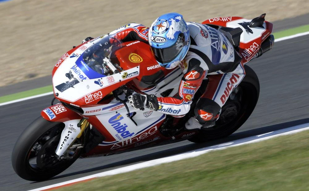 Carlos Checa avec son casque bleu symbolisant la Terre, une Ducati 1098 R rouge et blanche avec le nom Unibat