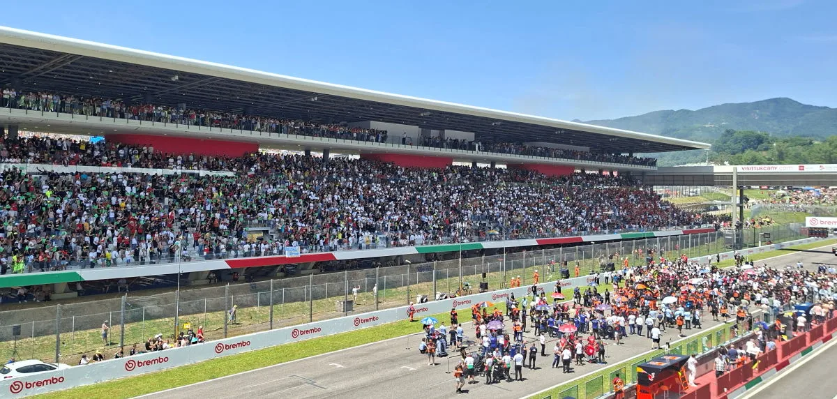 Une tribune remplie de spectateurs et une grille de départ d'une course moto