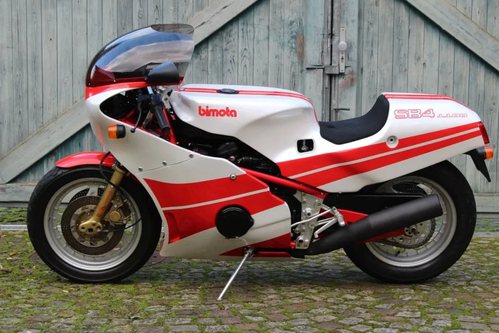 Bimota SB4 blanche et rouge devant une porte de garage