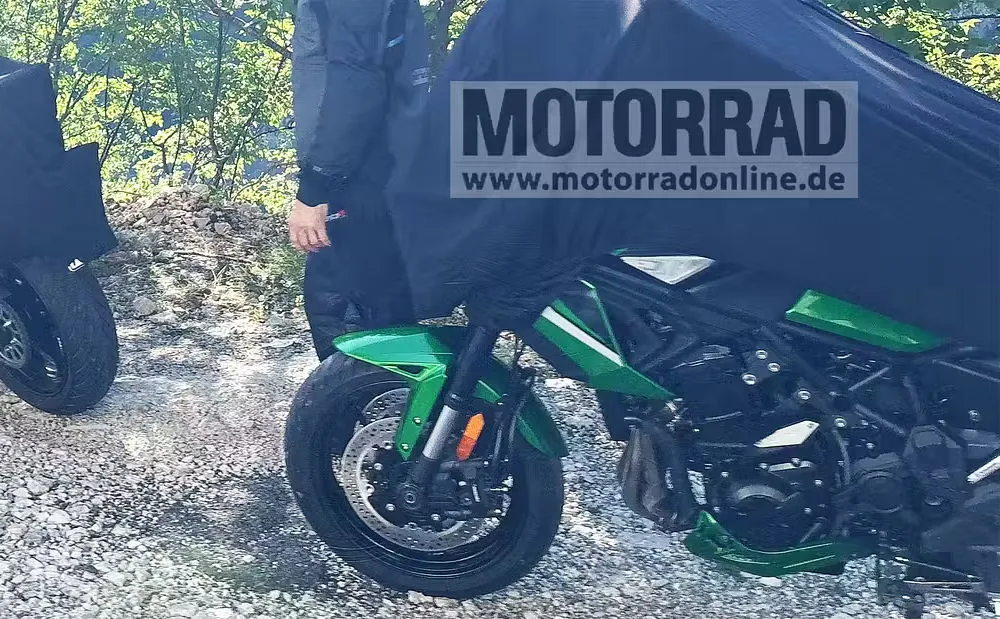 Une Kawasaki Versys 900 cachée par une bache noire, le mot Motorrad